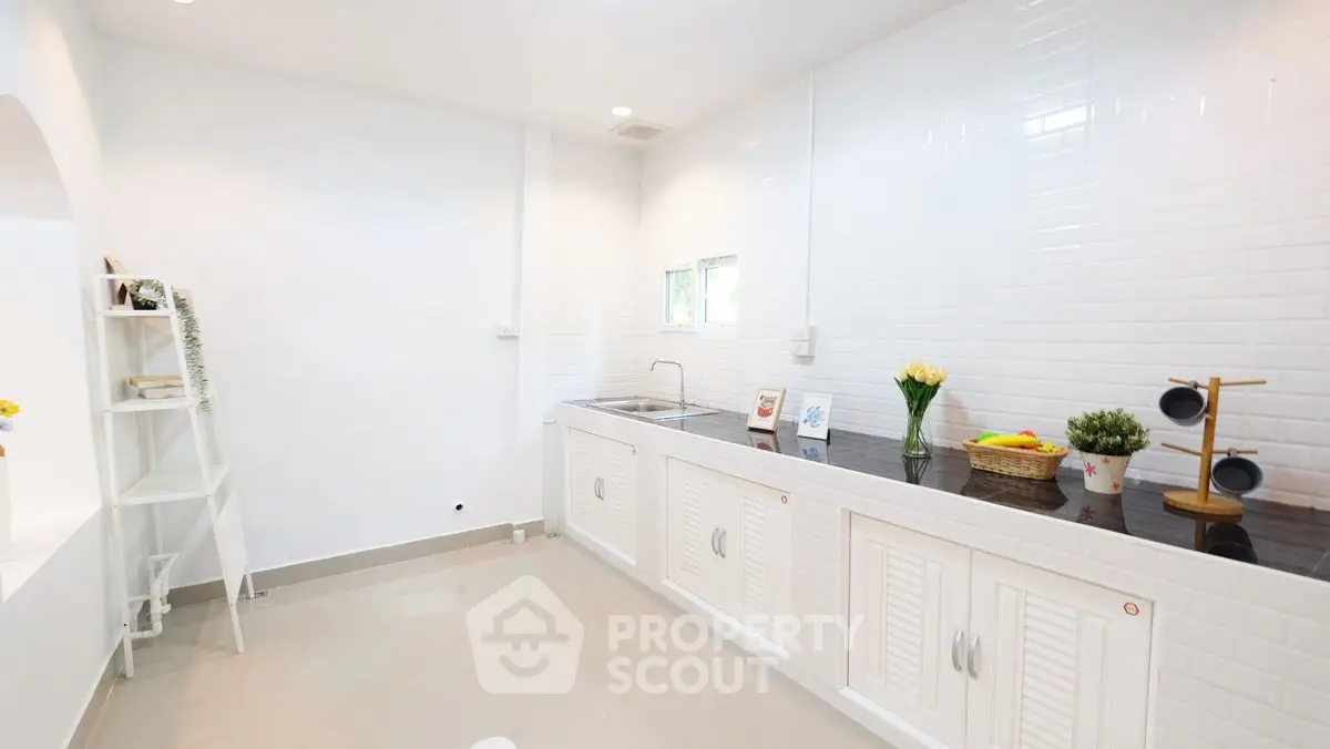 Spacious kitchen with sleek white cabinets and modern decor