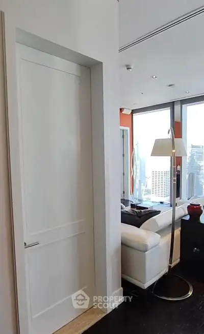 Modern living room with city view and sleek white furniture