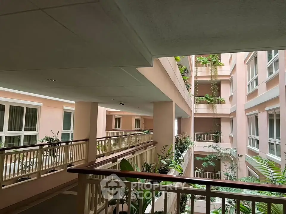 Elegant apartment building with lush greenery and open corridors for a serene living experience.