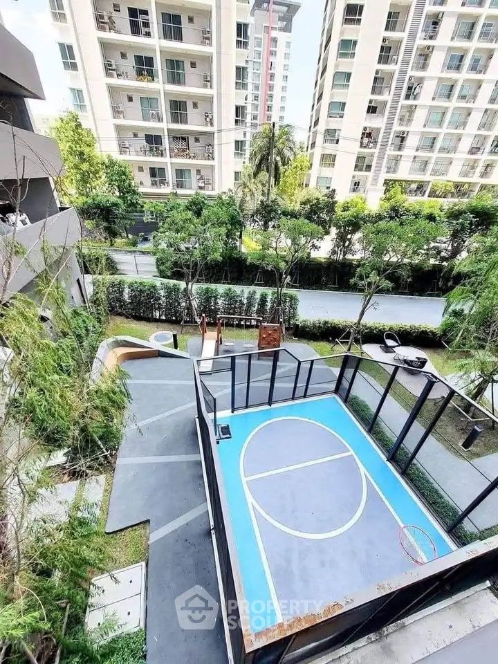 Modern residential complex with outdoor basketball court and lush greenery