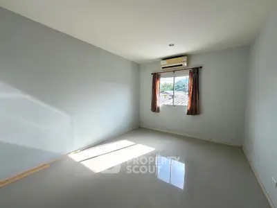Spacious empty room with natural light and air conditioning, ideal for customization.