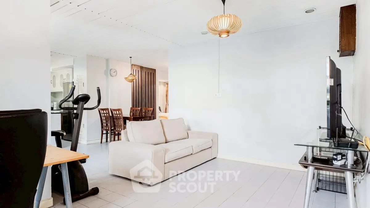 Spacious living room with modern decor and exercise equipment, perfect for relaxation and fitness.