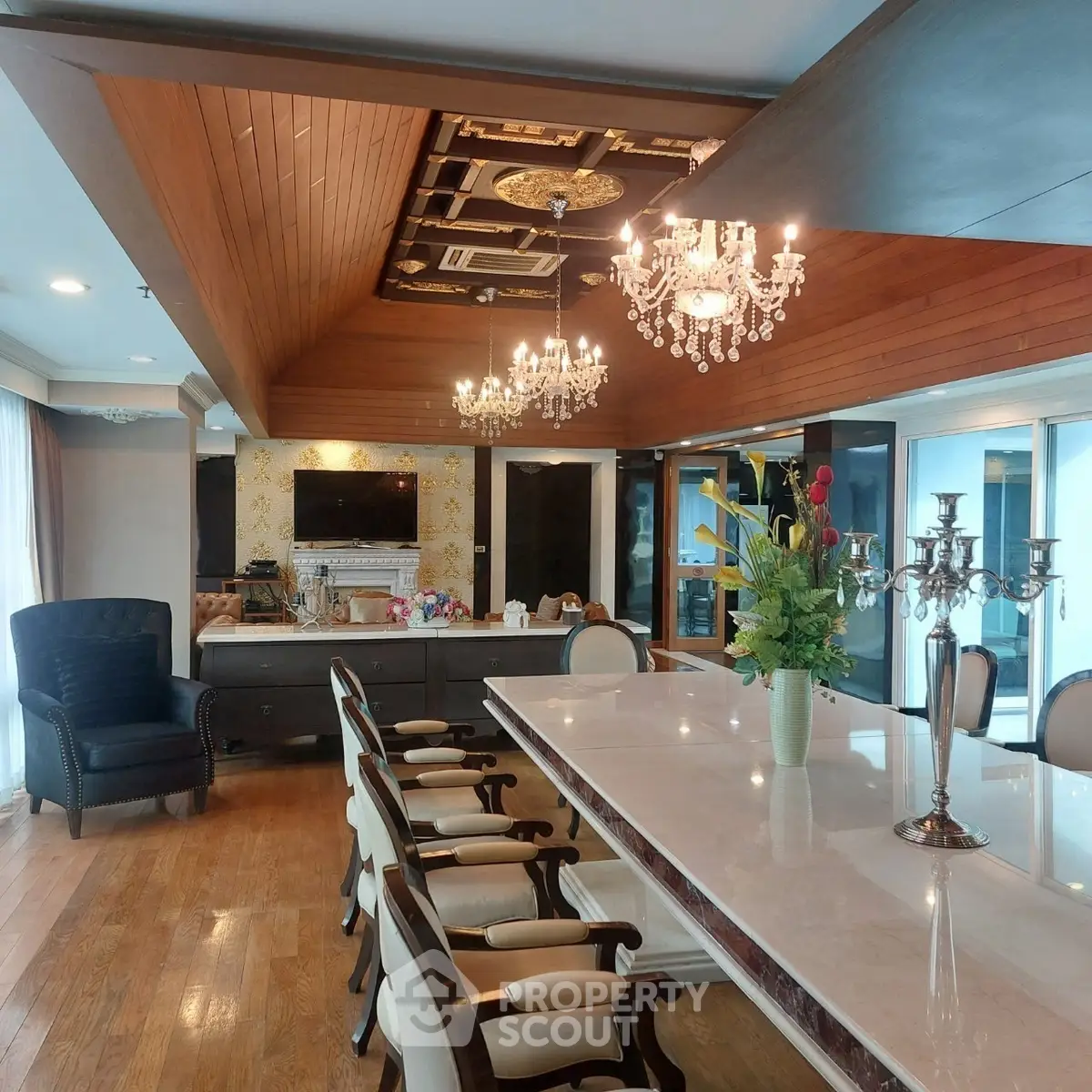 Luxurious dining room with elegant chandeliers and a spacious marble table.