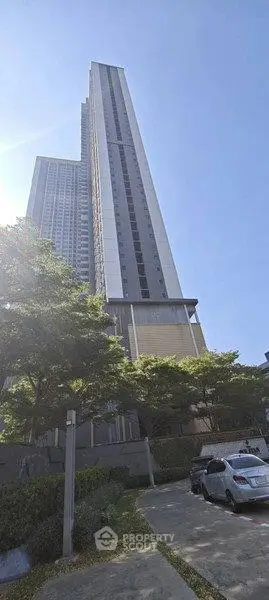 Stunning high-rise building with modern architecture and lush greenery, perfect for urban living.