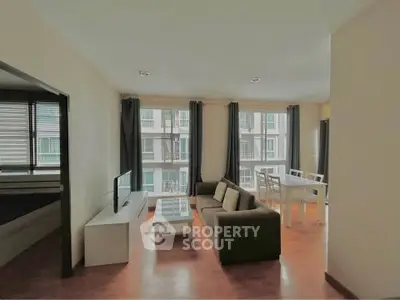 Spacious living room with modern furniture and large windows in a stylish apartment.