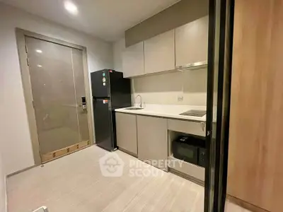 Modern kitchen with sleek cabinetry and built-in appliances in a compact layout.