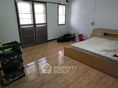 Spacious bedroom with simple furnishings and natural light