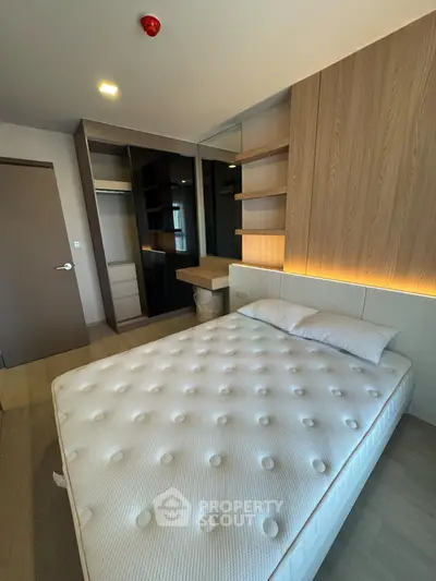 Modern bedroom with stylish wooden accents and cozy lighting, featuring a comfortable bed and ample storage space.