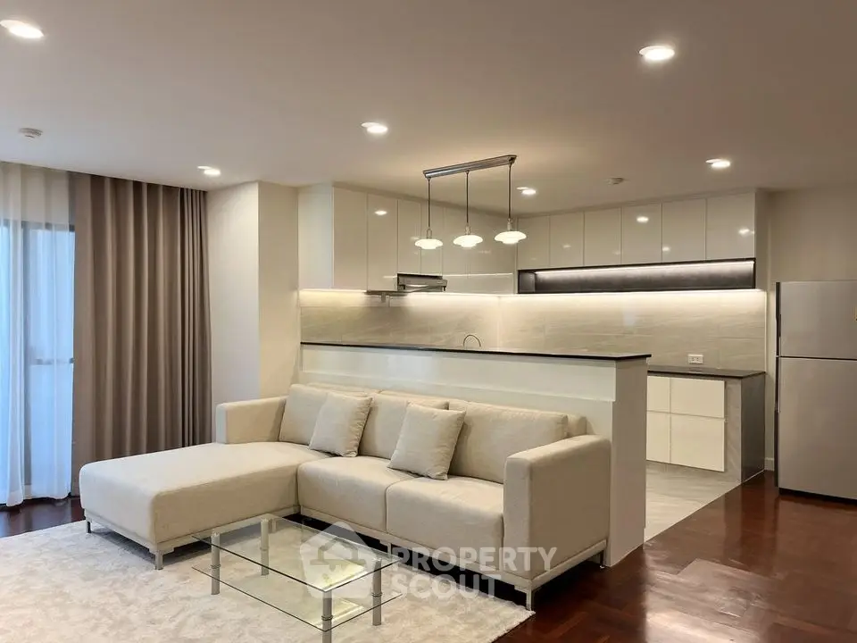 Modern open-layout living room with elegant kitchen and cozy sofa in a stylish apartment.