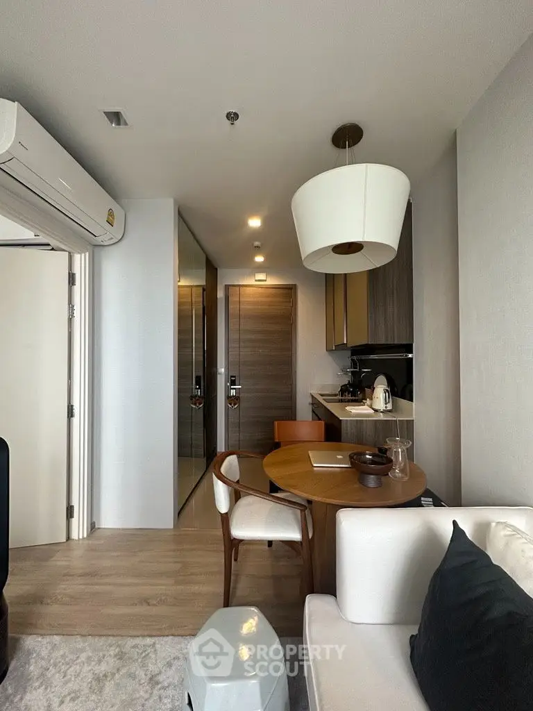 Stylish modern living room with dining area and sleek kitchen in compact apartment.