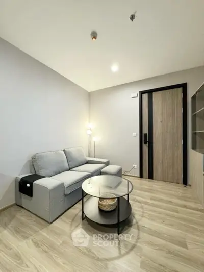 Modern living room with cozy gray sofa and stylish glass coffee table