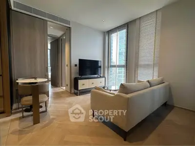 Modern living room with sleek furniture and large windows in a high-rise apartment.