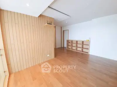 Spacious modern living room with wooden flooring and built-in shelving.