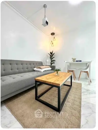 Modern living room with stylish gray sofa, wooden coffee table, and elegant decor.