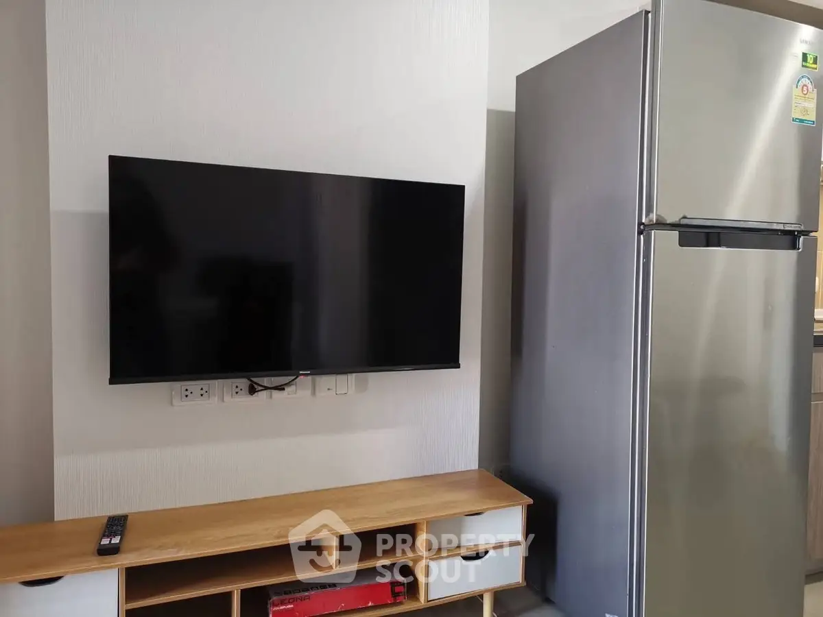 Modern living room with wall-mounted TV and sleek refrigerator