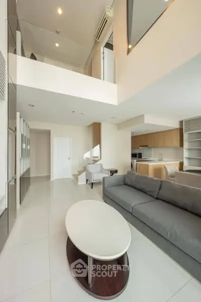 Spacious modern living room with high ceiling and open kitchen layout