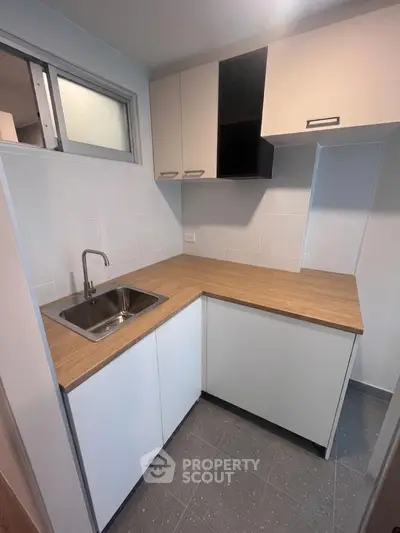 Modern compact kitchen with sleek cabinetry and stainless steel sink