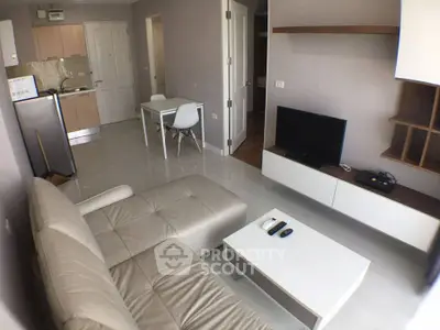 Modern living room with open kitchen layout and sleek furniture