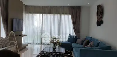 Spacious living room with modern decor and large windows for natural light