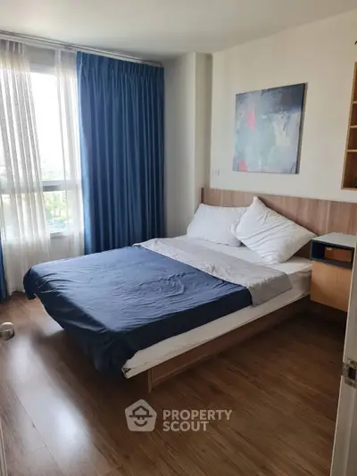 Cozy bedroom with modern decor and large window for natural light