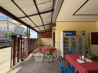 Charming outdoor patio with covered seating area and fridge, perfect for relaxation and entertaining.