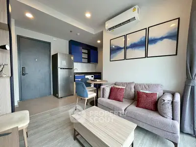 Modern living room with stylish decor and compact kitchen in open layout apartment.