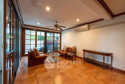 Spacious living room with elegant tile flooring and large windows for natural light.
