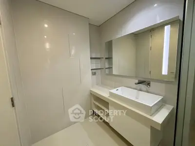 Modern bathroom with sleek white vanity and large mirror, perfect for contemporary living.
