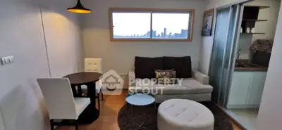 Cozy living room with city view, modern furniture, and adjacent kitchenette.