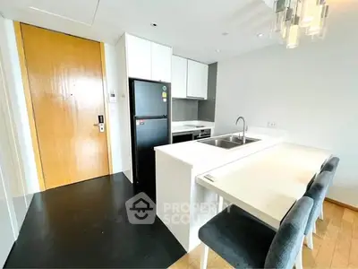 Modern kitchen with sleek design, featuring a breakfast bar and stainless steel appliances.