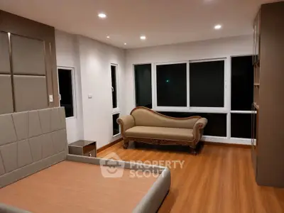 Spacious modern bedroom with elegant wooden flooring and stylish furniture