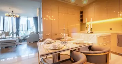 Luxurious open-plan kitchen and living room with elegant dining setup and city view.