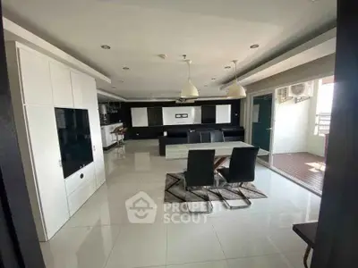 Spacious modern living room with sleek dining area and balcony access