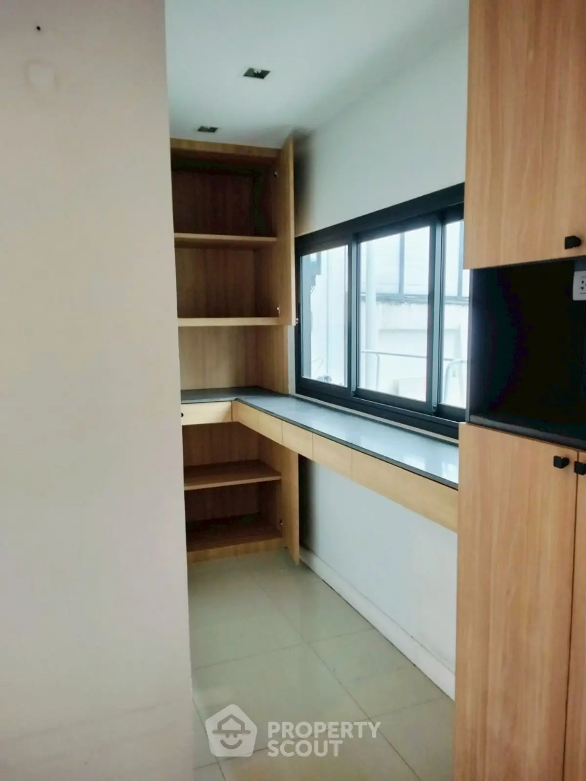 Modern study room with built-in wooden shelves and large window