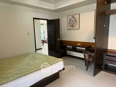 Spacious bedroom with modern furniture and natural light, ideal for comfortable living.