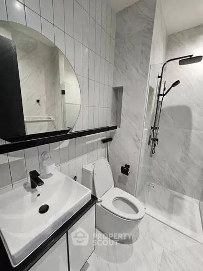 Modern bathroom with sleek design, featuring a glass shower and stylish fixtures.