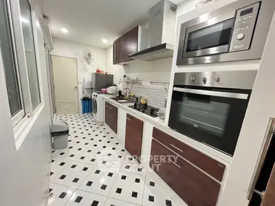 Modern kitchen with sleek appliances and stylish cabinetry in a compact layout.