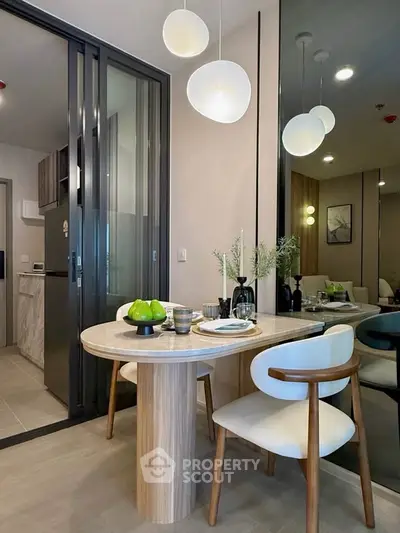 Modern dining area with elegant table and chairs, adjacent to a stylish living room in a contemporary apartment.