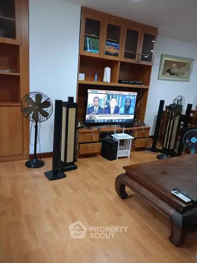 Spacious living room with wooden flooring and entertainment center