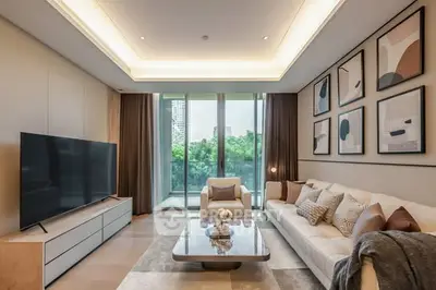 Luxurious living room with modern decor and large TV, overlooking lush greenery.