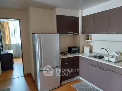 Modern kitchen with sleek cabinets and stainless steel fridge in cozy apartment