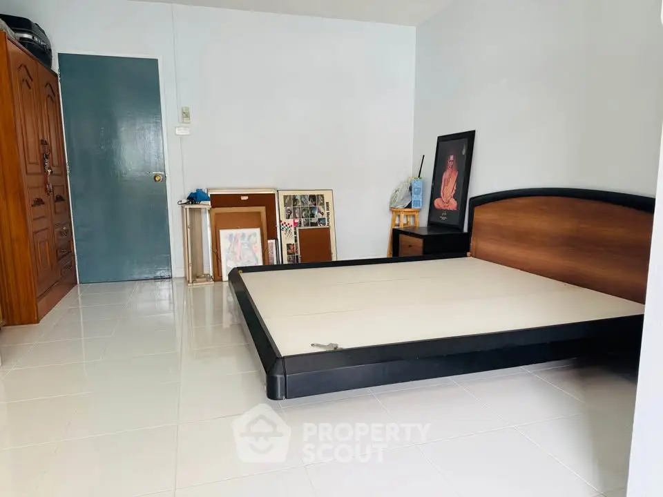 Spacious bedroom with modern bed frame and art decor, perfect for personalizing your living space.