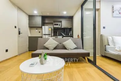 Modern open-plan living room with sleek kitchen and cozy seating area