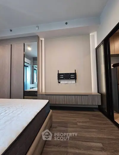 Modern bedroom with mounted TV bracket and sleek wooden flooring
