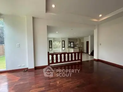 Spacious open-plan living area with hardwood floors and natural light