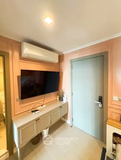 Modern living room with wall-mounted TV and air conditioning unit, featuring stylish decor and soft lighting.
