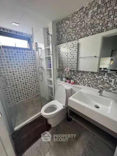 Modern bathroom with mosaic tiles and glass shower enclosure