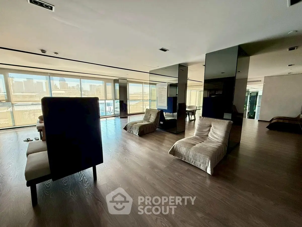 Spacious modern living room with floor-to-ceiling windows and city view.