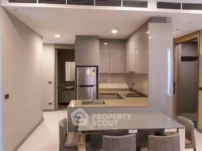 Modern kitchen with sleek cabinetry and dining area in stylish apartment