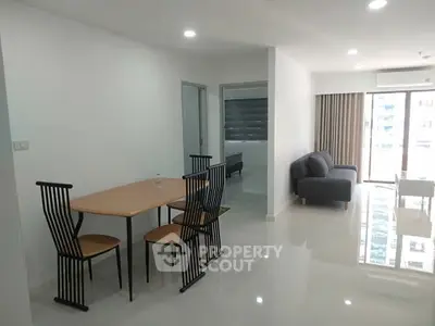 Modern open-plan living and dining area with sleek furniture and bright natural lighting.